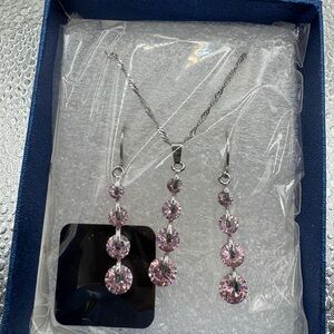 silver-toned necklace three-stone pendant matching three-stone dangle earrings.